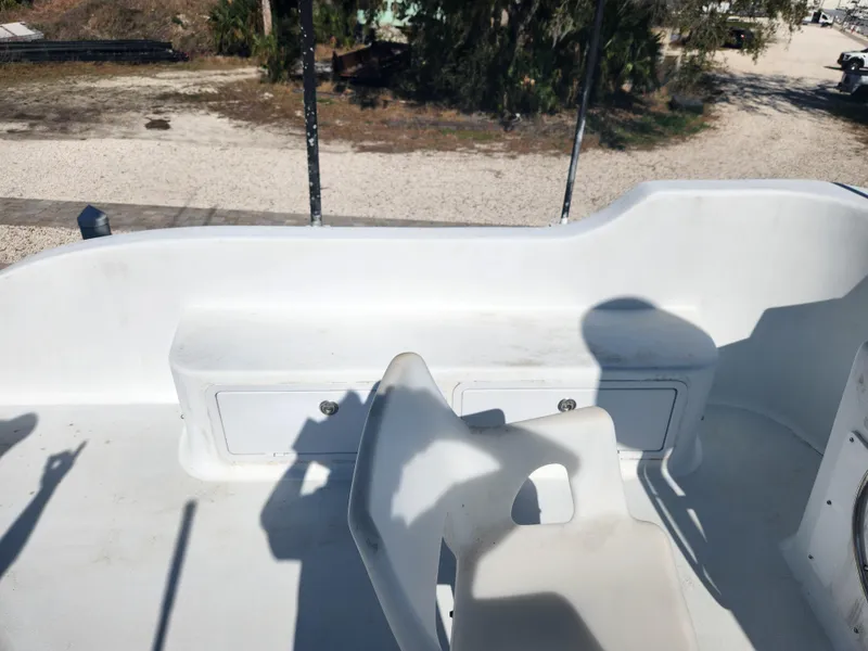 Slide: The Image of White deck area of a 1983 Custom 76 Trawler with seating and storage compartments. - 7