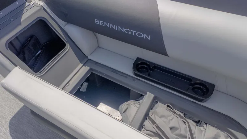 Slide: The Image of 2025 Bennington 20SSRSE boat interior with storage compartment and cup holders. - 12