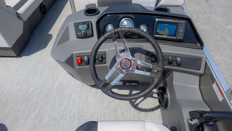 Slide: The Image of 2025 Bennington 20SSRSE boat dashboard with steering wheel, gauges, and navigation system. - 17