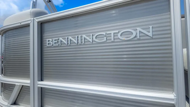Slide: The Image of 2025 Bennington 20SSRSE pontoon boat with sleek metallic finish under blue sky. - 4