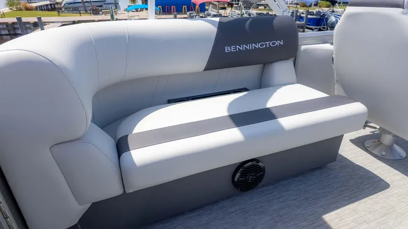 Slide: The Image of 2025 Bennington 20SSRSE boat seat with gray upholstery and logo, docked at marina. - 7