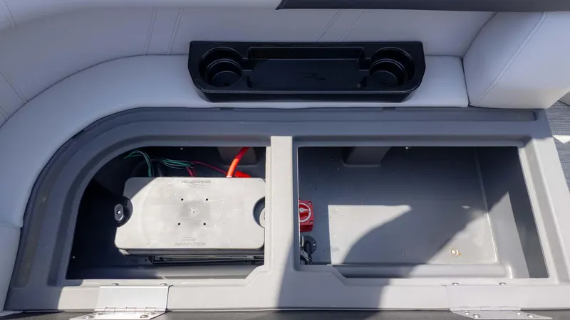 Slide: The Image of 2025 Bennington 20SSRSE boat storage compartment with battery and cup holders. - 8