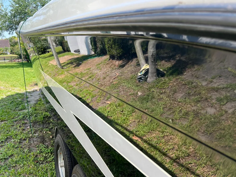 Slide: The Image of 2012 Hydra-Sports 3400 CC boat with reflective hull, parked on grass. - 10