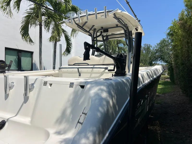 Slide: The Image of 2012 Hydra-Sports 3400 CC boat docked near palm trees, showcasing sleek design. - 13