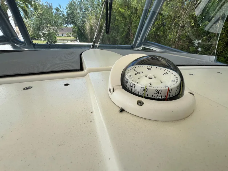 Slide: The Image of 2012 Hydra-Sports 3400 CC boat compass on dashboard, surrounded by trees. - 40