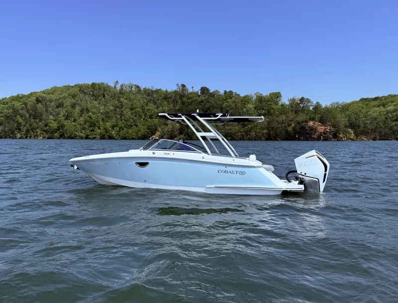 Slide: The Image of 2019 Cobalt 25SC boat on a lake with forested shoreline in the background. - 1