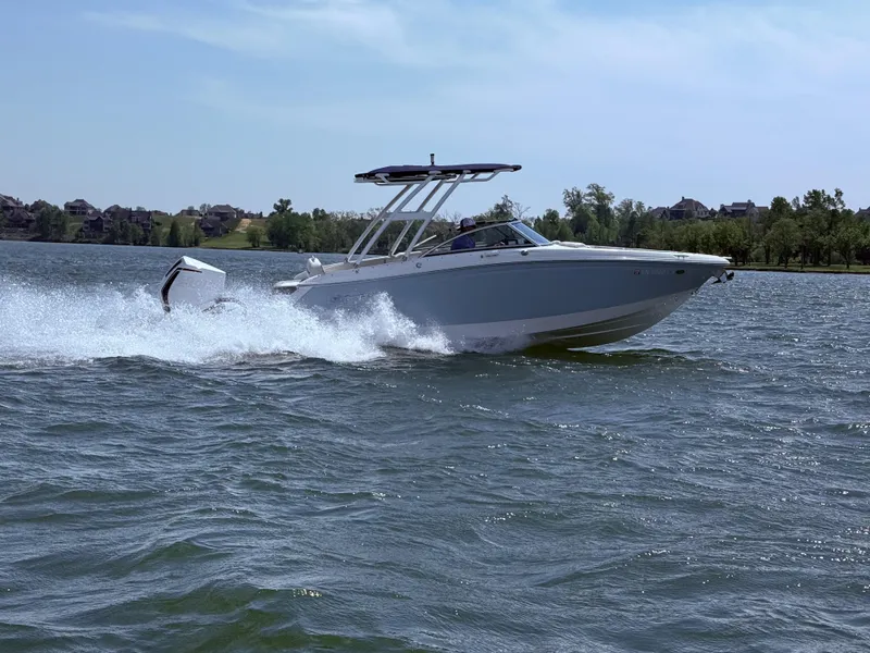 Slide: The Image of 2019 Cobalt 25SC boat cruising on a lake with scenic background. - 5
