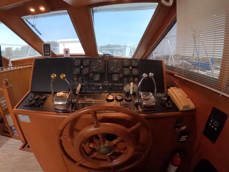 Slide: The Image of Helm of 1995 Jefferson 48 Rivanna yacht with wooden steering wheel and control panel. - 12