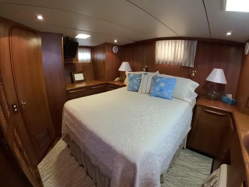 Slide: The Image of Luxurious bedroom interior of 1995 Jefferson 48 Rivanna yacht with cozy bedding and wooden furnishings. - 15