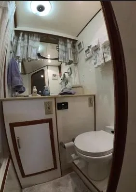 Slide: The Image of Bathroom interior of a 1995 Jefferson 48 Rivanna yacht, featuring a toilet and vanity. - 18