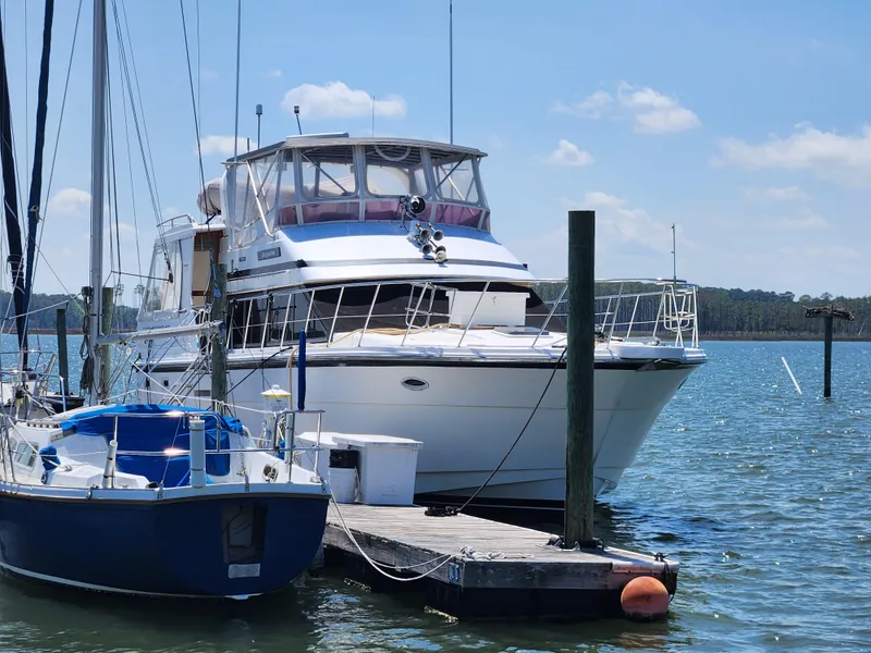 Slide: The Image of 1995 Jefferson 48 Rivanna yacht docked beside a sailboat on a sunny day. - 2