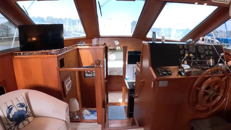 Slide: The Image of Interior of a 1995 Jefferson 48 Rivanna yacht with wooden helm and seating area. - 21