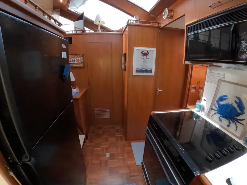 Slide: The Image of Interior of 1995 Jefferson 48 Rivanna yacht kitchen with wood cabinetry and modern appliances. - 24