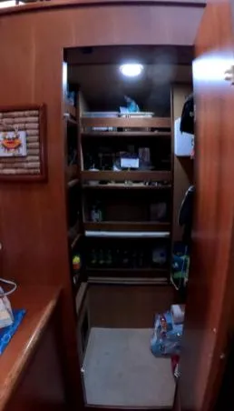 Slide: The Image of Interior storage space on a 1995 Jefferson 48 Rivanna boat, featuring wooden shelves and lighting. - 25