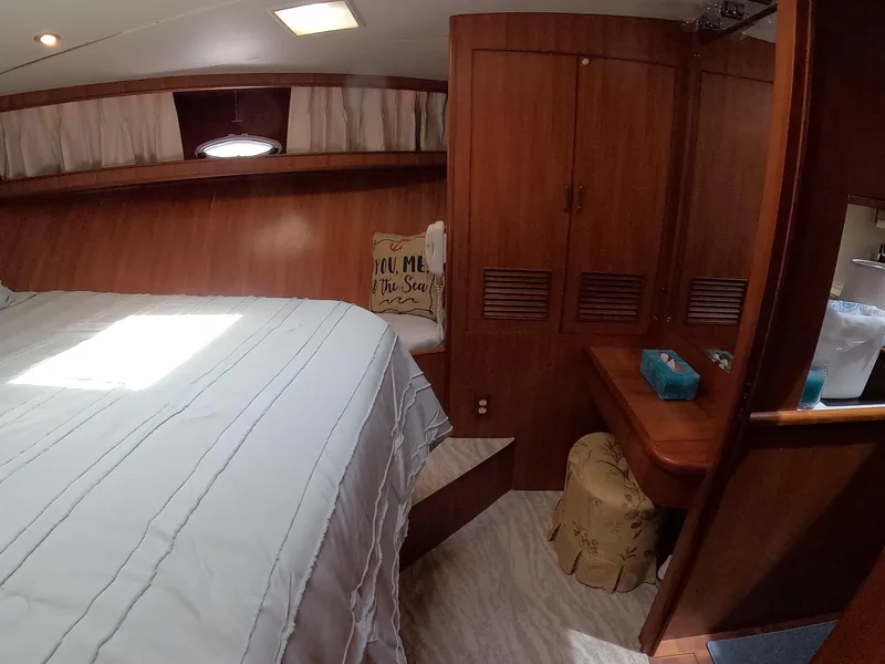 Slide: The Image of Cozy bedroom interior of 1995 Jefferson 48 Rivanna yacht with wood paneling and natural light. - 26