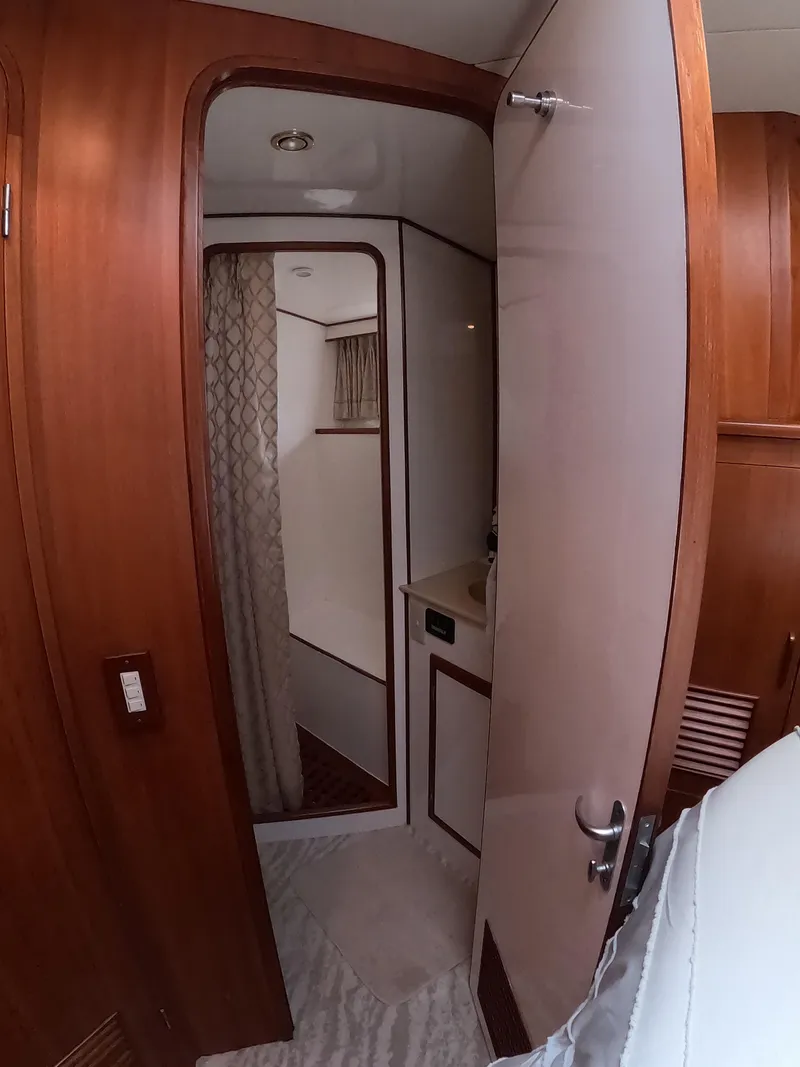Slide: The Image of Interior of 1995 Jefferson 48 Rivanna yacht, featuring a wooden door and compact bathroom. - 28