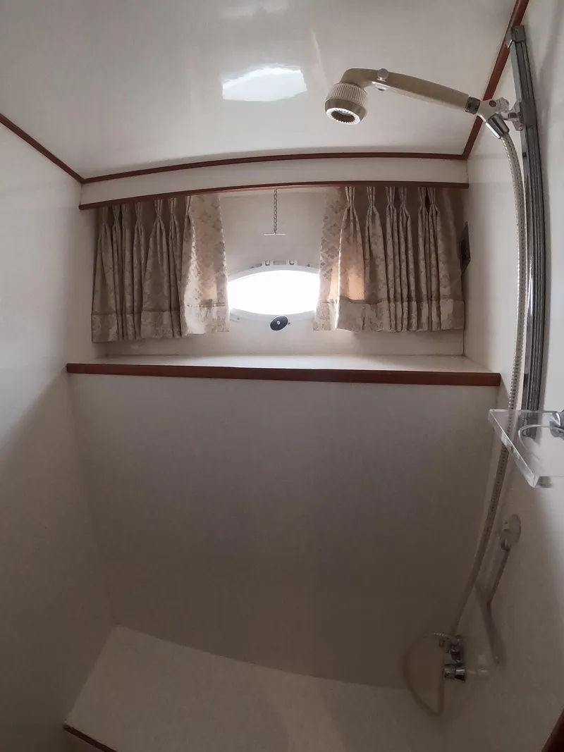 Slide: The Image of Shower area in a 1995 Jefferson 48 Rivanna yacht with curtains and window. - 30