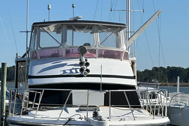 Slide: The Image of 1995 Jefferson 48 Rivanna yacht docked, front view with clear sky background. - 32