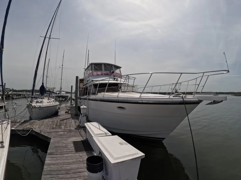Slide: The Image of 1995 Jefferson 48 Rivanna yacht docked at marina, surrounded by sailboats under cloudy sky. - 4