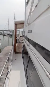 Slide: The Image of 1995 Jefferson 48 Rivanna yacht docked at marina, side view with railing and windows. - 6