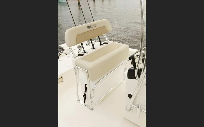 Slide: The Image of 2025 Pathfinder 2200 TRS boat seat with rod holders on a calm water background. - 10