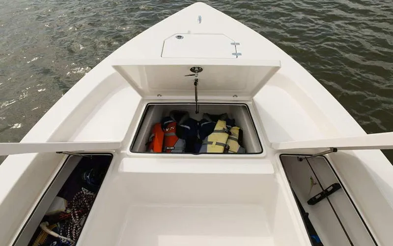 Slide: The Image of 2025 Pathfinder 2200 TRS boat storage compartments with life jackets on water. - 15