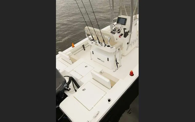 Slide: The Image of 2025 Pathfinder 2200 TRS boat interior with fishing rods and control console on water. - 7