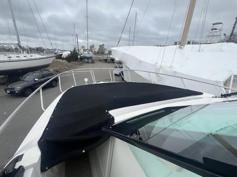 Slide: The Image of 2023 Sea Ray Sundancer 320 yacht with black cover, docked in a marina. - 12