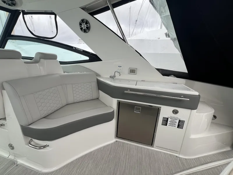 Slide: The Image of 2023 Sea Ray Sundancer 320 interior with seating and kitchenette area. - 16