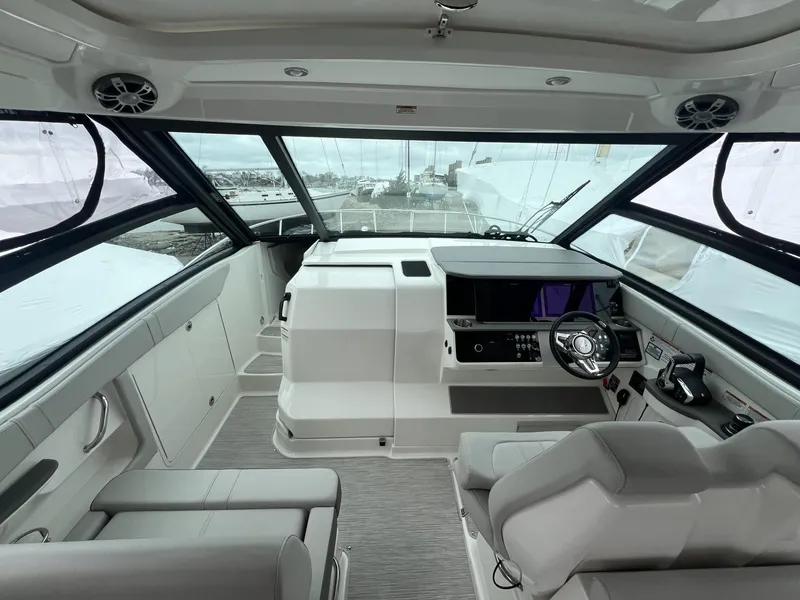 Slide: The Image of 2023 Sea Ray Sundancer 320 cockpit with modern controls and panoramic windows. - 19