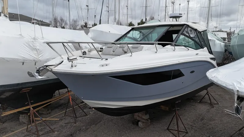 Slide: The Image of 2023 Sea Ray Sundancer 320 boat on stands, surrounded by other covered boats. - 2