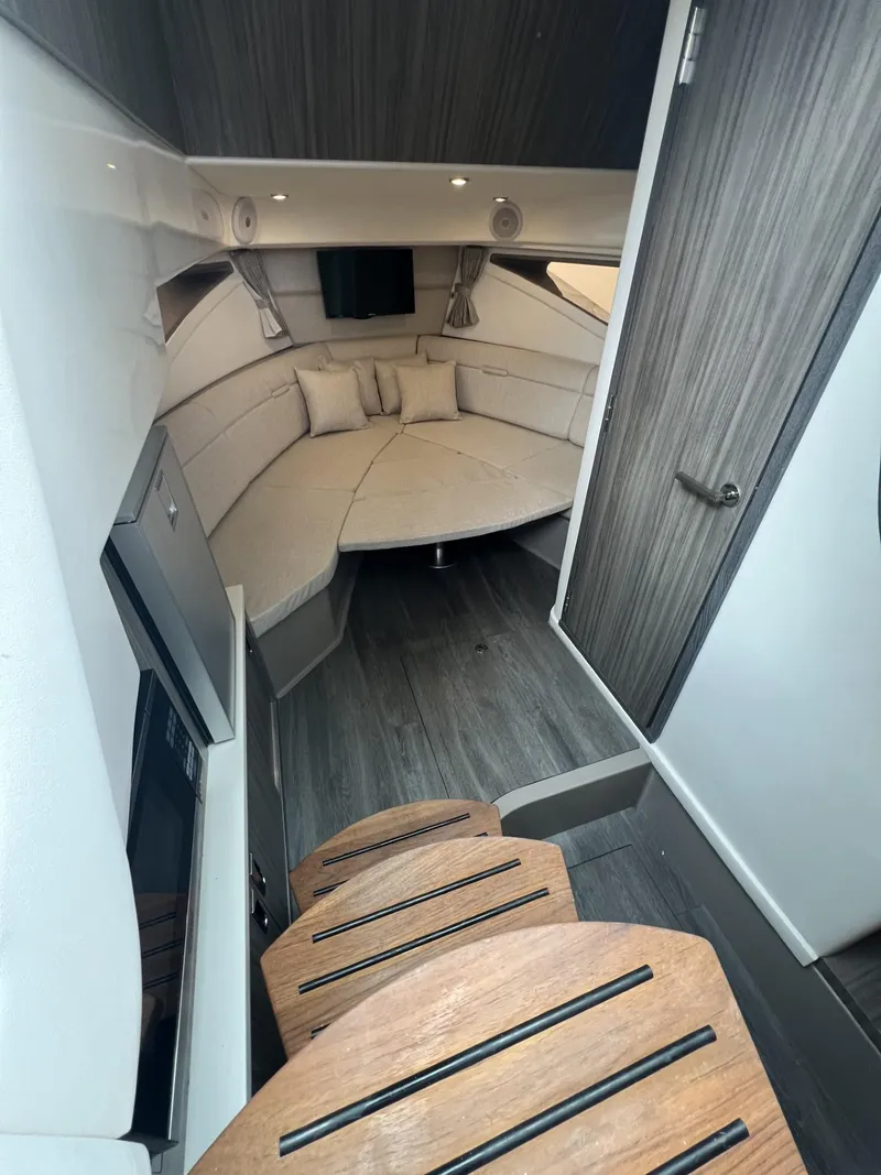 Slide: The Image of 2023 Sea Ray Sundancer 320 cabin interior with modern design and wooden steps. - 23