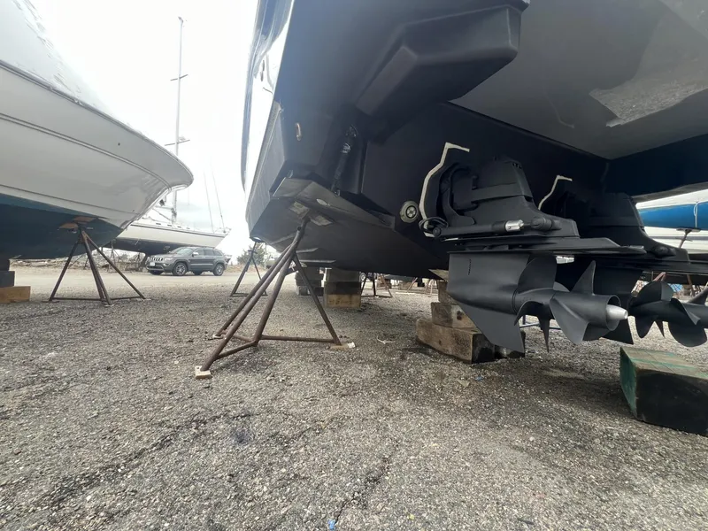 Slide: The Image of 2023 Sea Ray Sundancer 320 boat on stands, showcasing propellers and hull. - 31