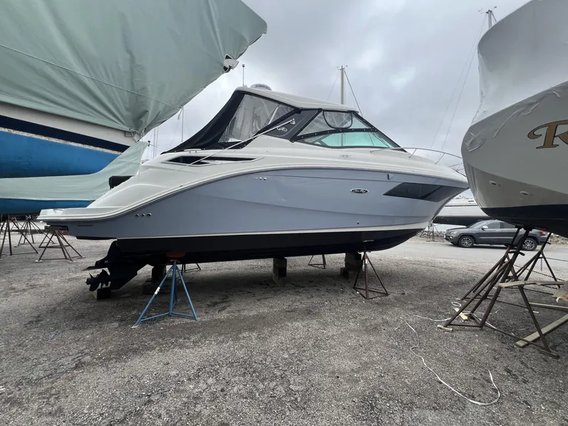 Slide: The Image of 2023 Sea Ray Sundancer 320 yacht on stands in a boatyard, overcast sky. - 4