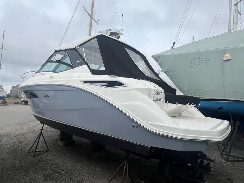Slide: The Image of 2023 Sea Ray Sundancer 320 boat on stands, featuring sleek design and black canopy. - 6