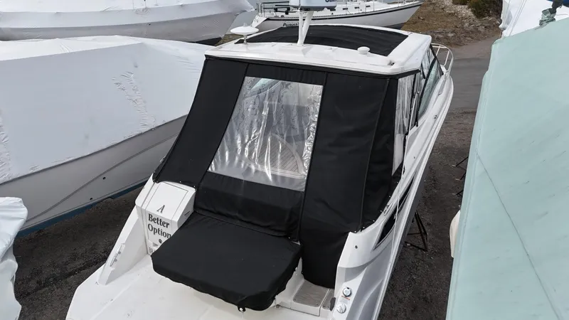 Slide: The Image of 2023 Sea Ray Sundancer 320 boat with black cover, docked outdoors. - 7