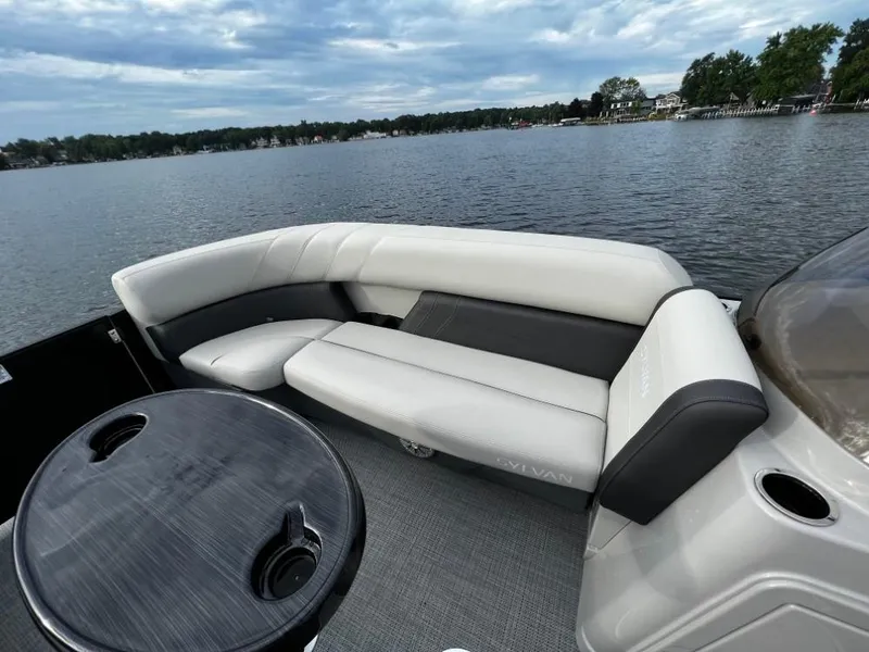 Slide: The Image of 2025 Sylvan Mirage X3 Party Fish boat interior with comfortable seating on a serene lake. - 14