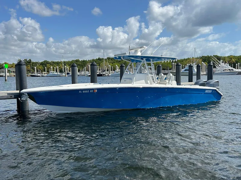 Slide: The Image of 2019 Sea Tech 33 boat docked in marina, blue hull, clear sky, calm water. - 0