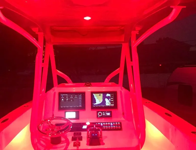 Slide: The Image of Red-lit cockpit of a 2019 Sea Tech 33 boat with navigation screens. - 11