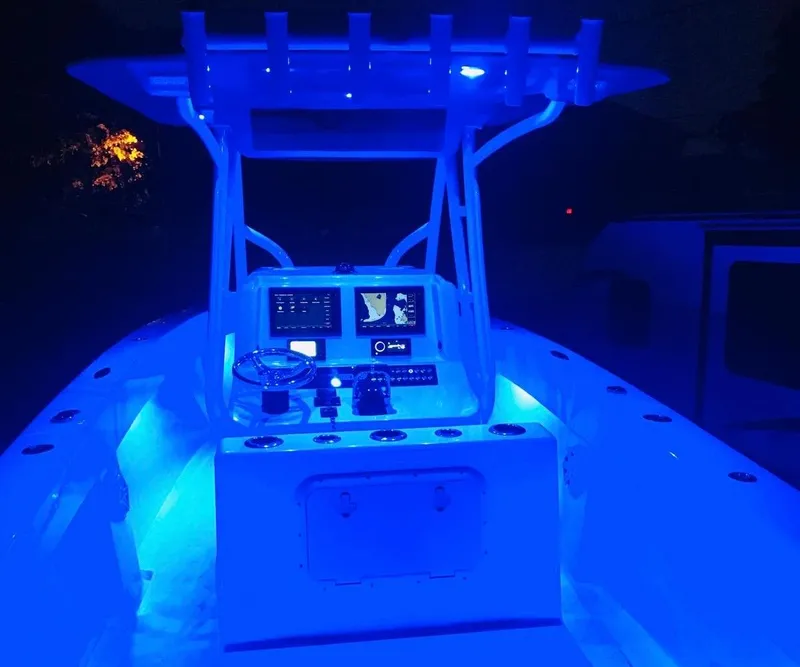 Slide: The Image of 2019 Sea Tech 33 boat cockpit illuminated with blue LED lights at night. - 12