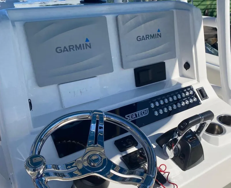 Slide: The Image of 2019 Sea Tech 33 boat dashboard with Garmin displays and steering wheel. - 13