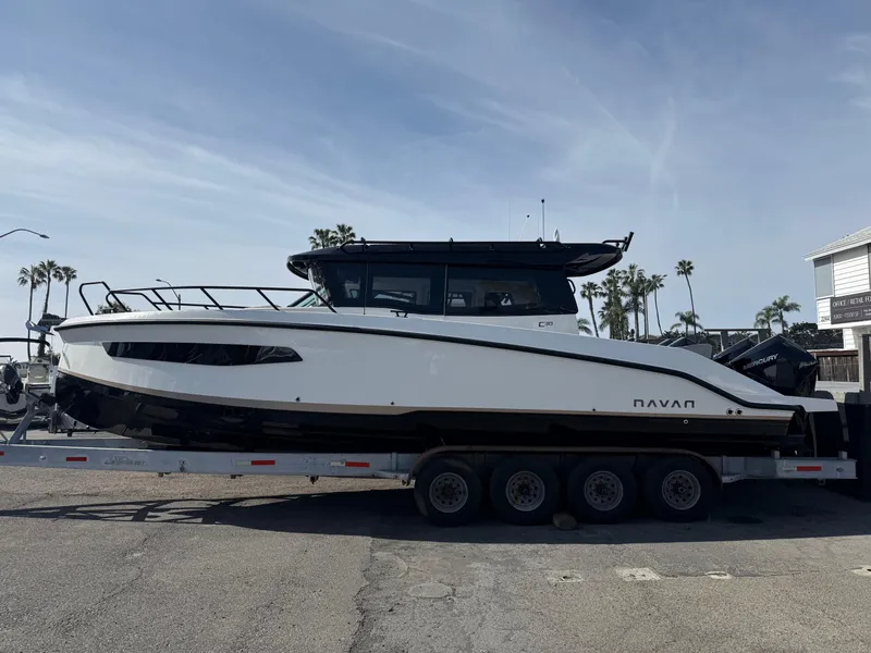 Slide: The Image of 2025 Navan C30 boat on trailer, parked outdoors, with palm trees in the background. - 1