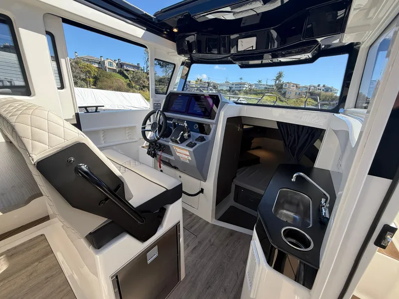 Slide: The Image of Interior of 2025 Navan C30 boat with modern helm, seating, and compact kitchenette. - 17