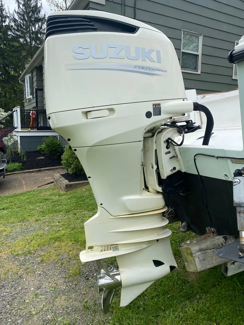 Slide: The Image of 1982 Master Marine 28 Center Console with Suzuki outboard motor in a residential yard. - 11