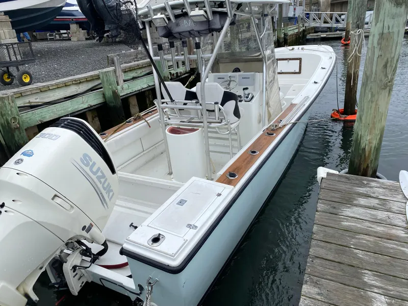 Slide: The Image of 1982 Master Marine 28 Center Console boat docked, featuring a Suzuki outboard motor. - 4