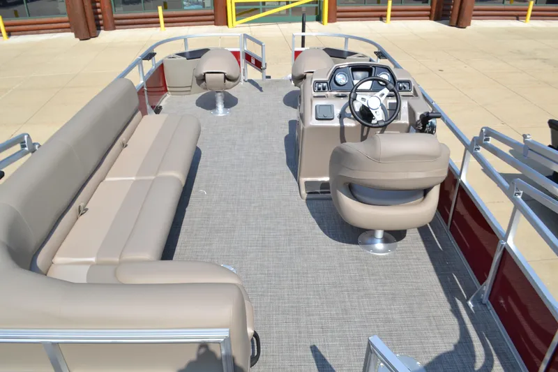 Slide: The Image of 2024 Ranger Reata 200F pontoon boat interior with beige seating and steering console. - 3