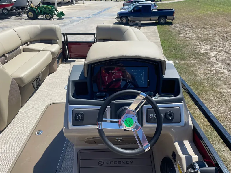 Slide: The Image of 2024 Regency 230 LE3 Sport boat interior with steering wheel and dashboard display. - 4