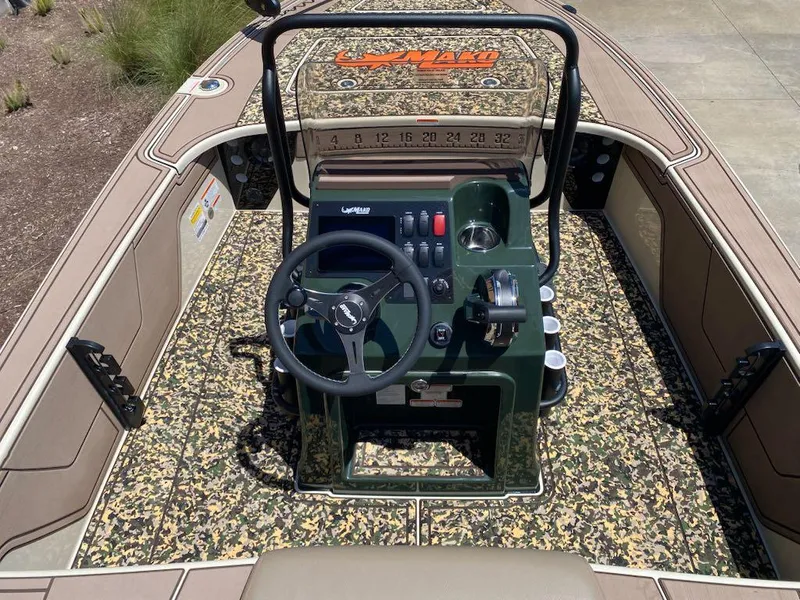 Slide: The Image of 2025 Mako 18 Pro Skiff Backwater Edition boat interior with camo design and steering console. - 7