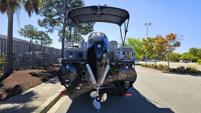 Slide: The Image of 2024 Regency 230 LE3 Sport pontoon boat with canopy, parked outdoors. - 7