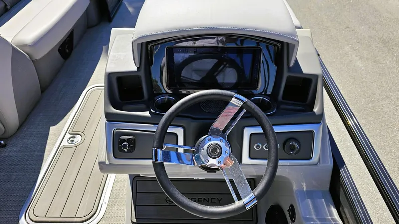 Slide: The Image of 2024 Regency 230 LE3 Sport boat dashboard with steering wheel and control panel. - 8